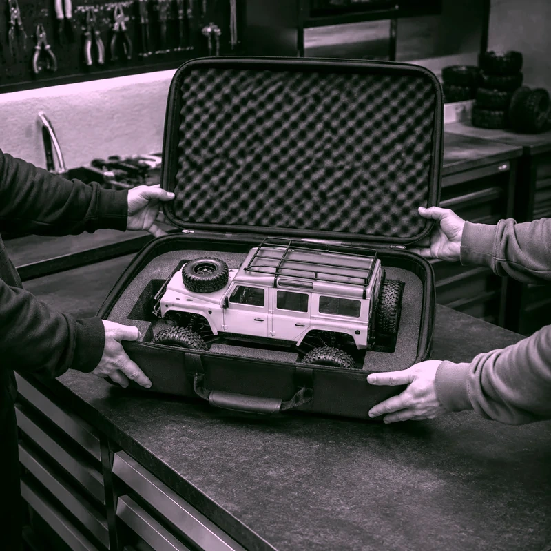 Persona retirando un auto RC terminado en su caja protectora